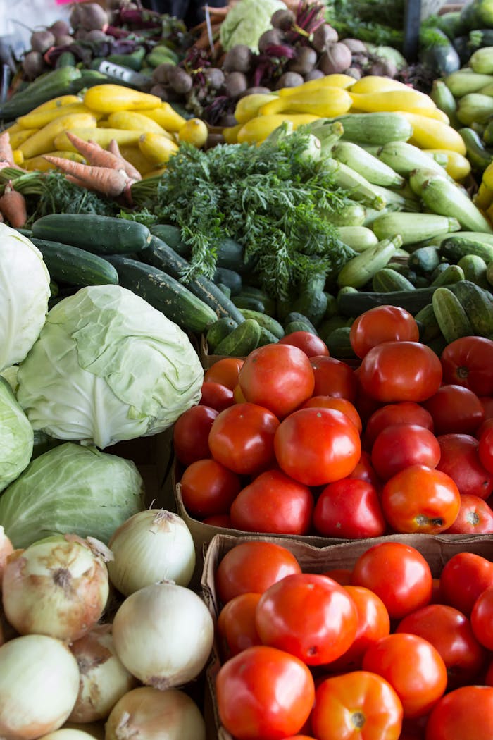 gallery-05 Vibrant display of organic vegetables including tomatoes, cabbages, and more at a North Carolina market.